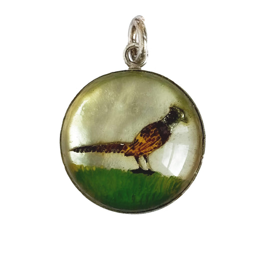 A vintage sterling silver reverse crystal pheasant charm on a white background.