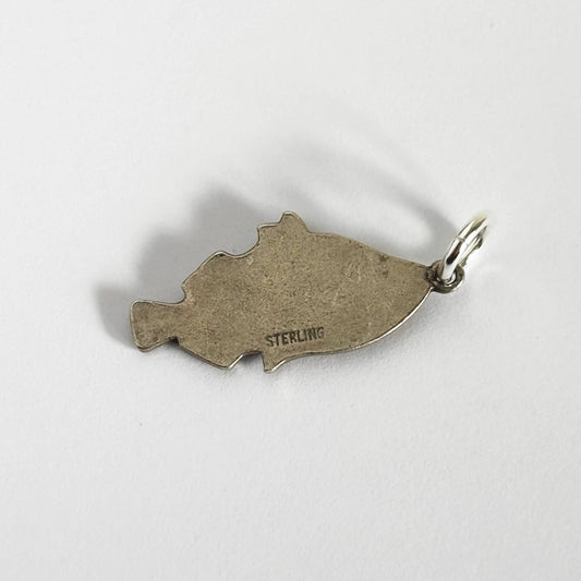 Back of a vintage silver tropical fish charm on a white background