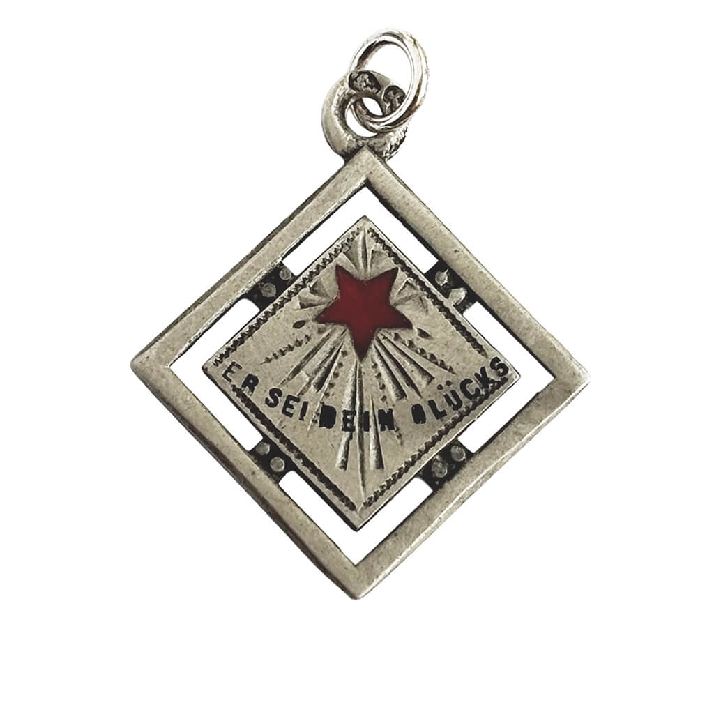 An antique silver and enamel Austrian lucky star charm on a white background.