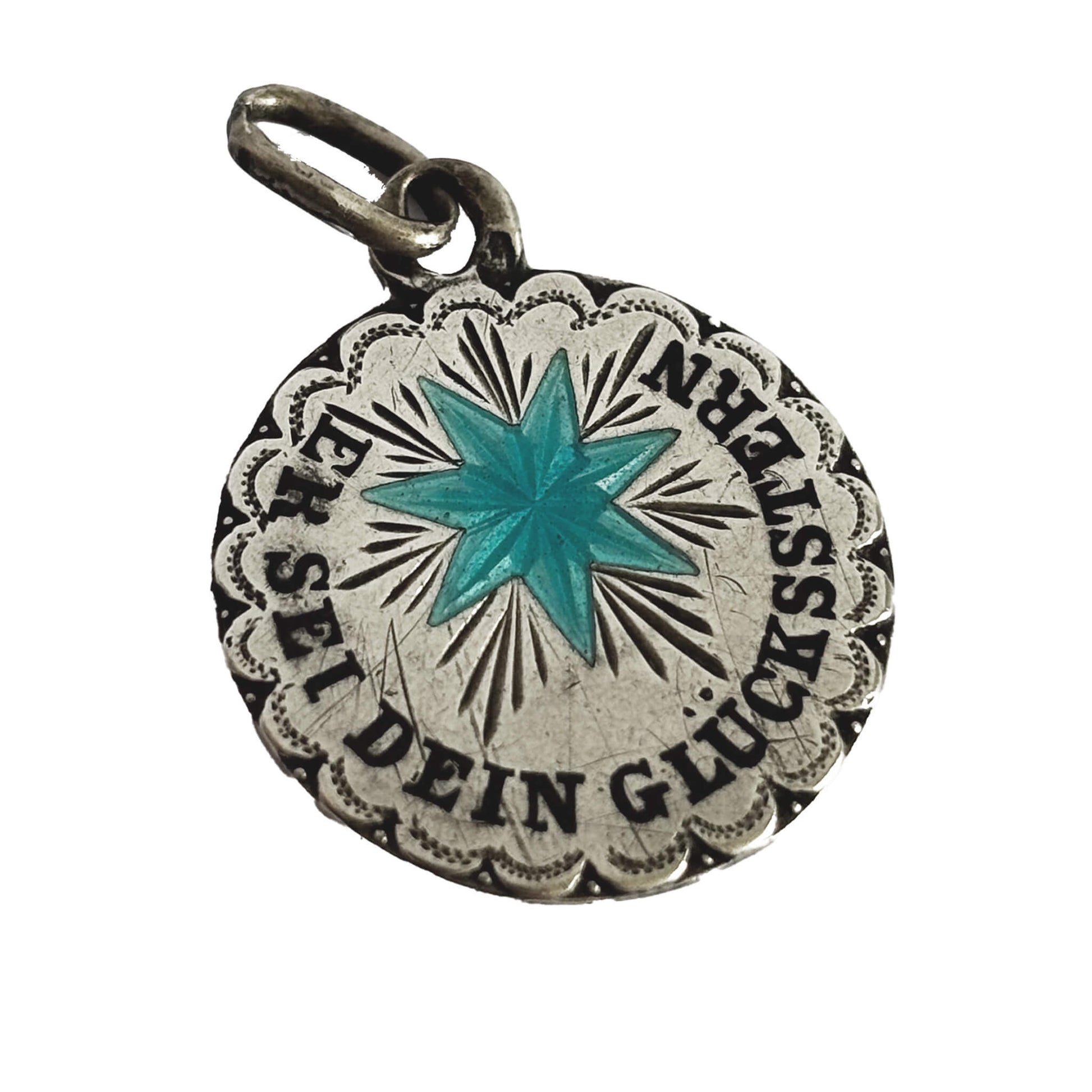 Silver pendant with turquoise star and German text on a white background