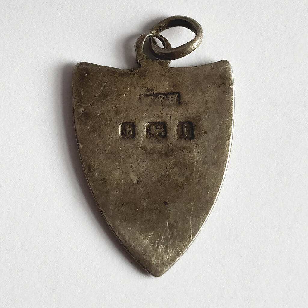 Antique shield charm reverse with 1908 Birmingham hallmarks on white background