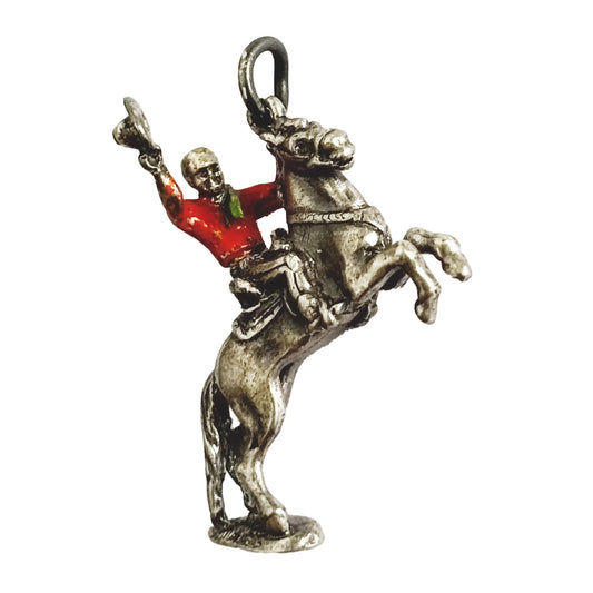 Cowboy on rearing horse silver charm with red enamel shirt on white background
