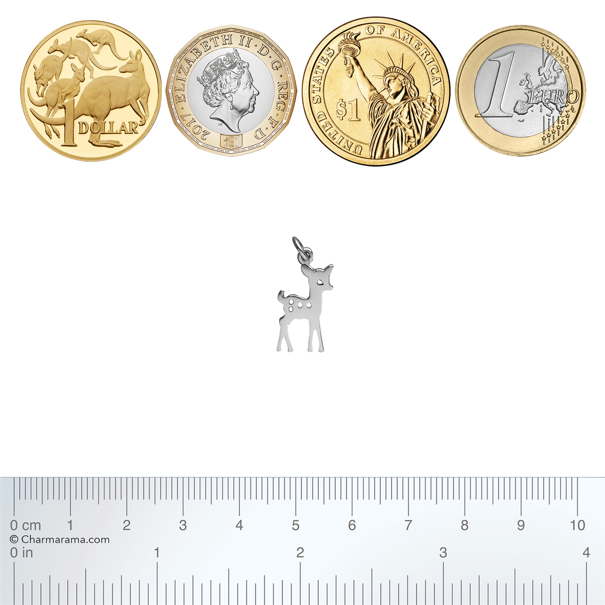 Silver deer charm next to various international coins with a ruler for scale.