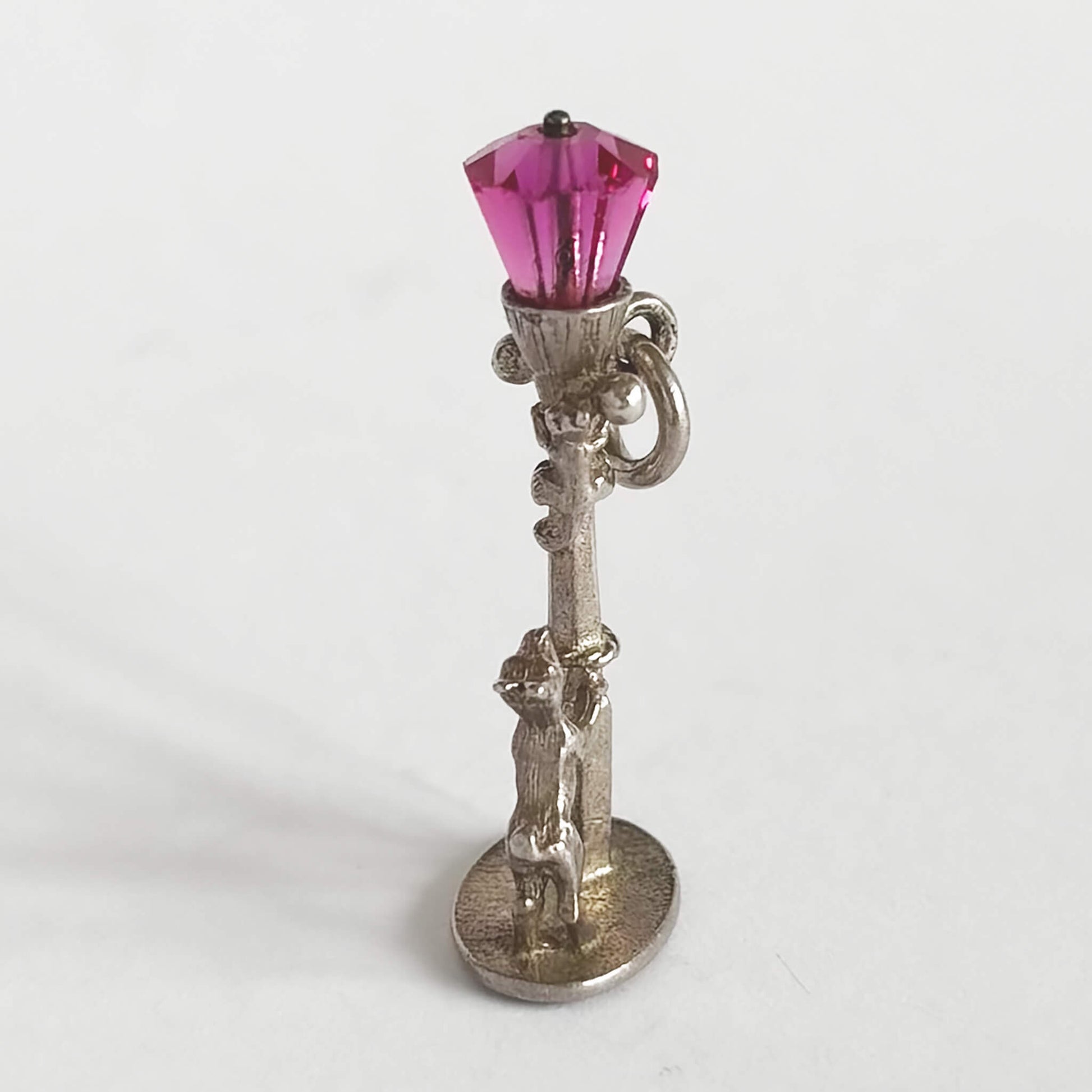 Dog chasing cat up lamppost charm with pink crystal