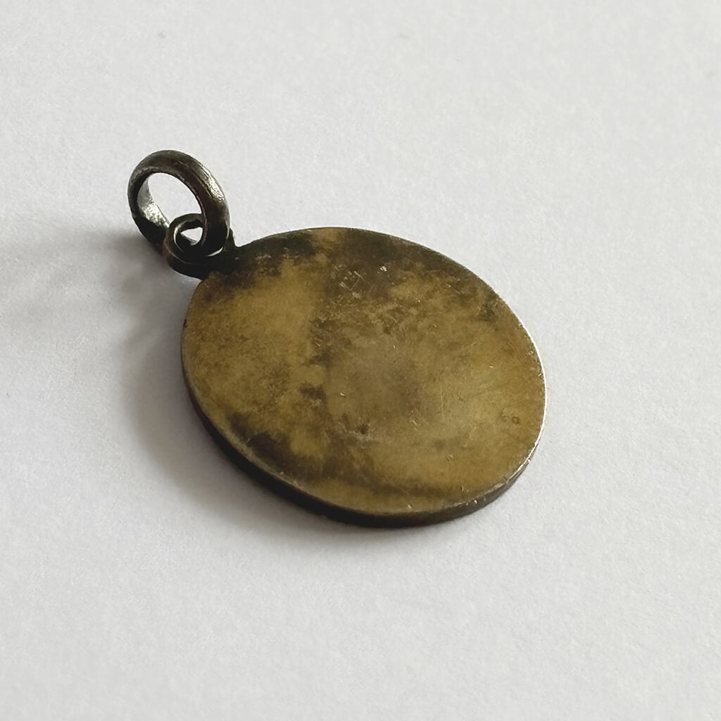 Round brass pendant on a white background