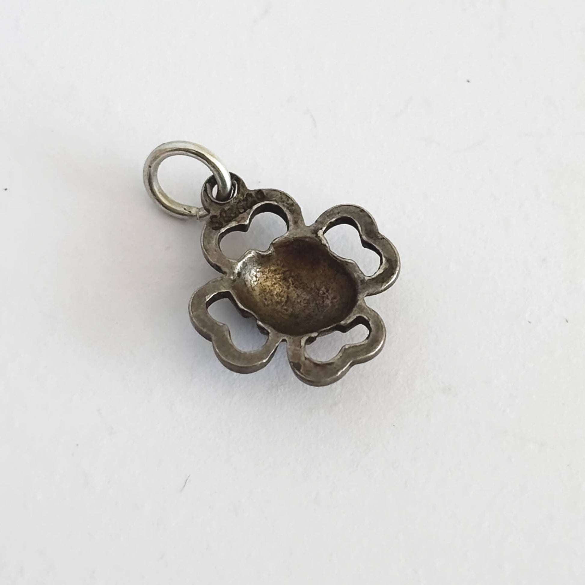 back of silver four leaf clover pendant on a white background
