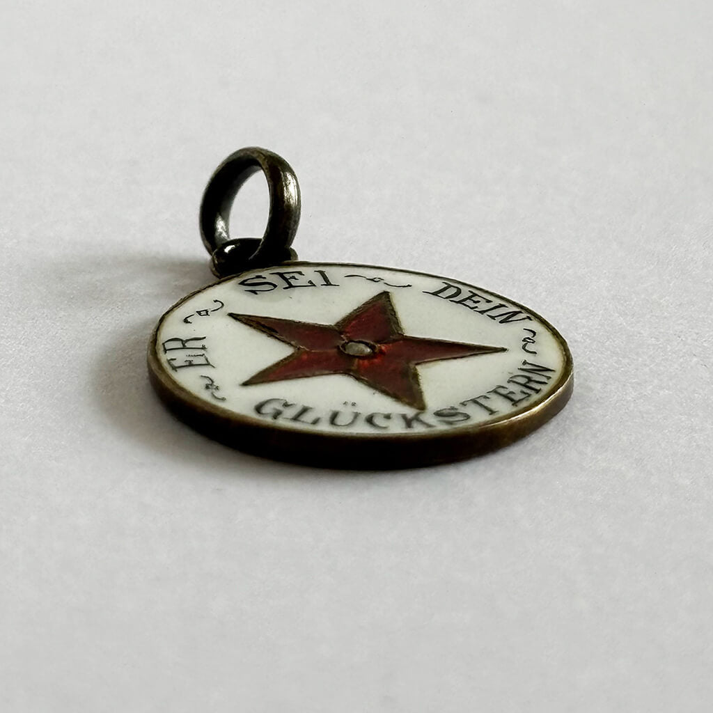 Pendant with star design and text on a white background