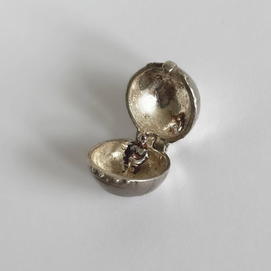 Vintage silver Nuvo football charm open to football player on a white background