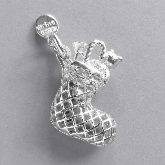 Silver Christmas stocking charm on a grey background