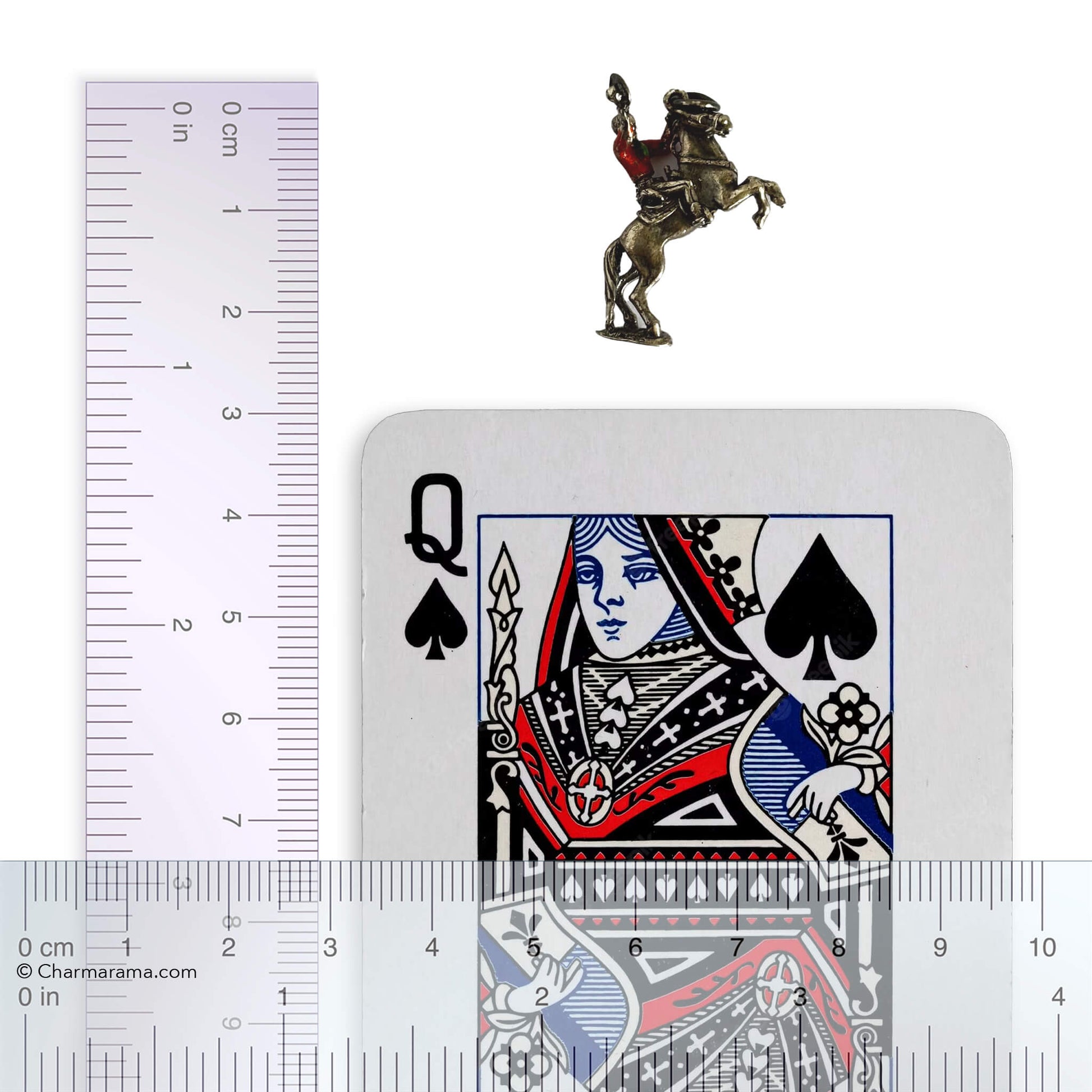 Cowboy on rearing horse silver charm with playing card and ruler for scale on white background