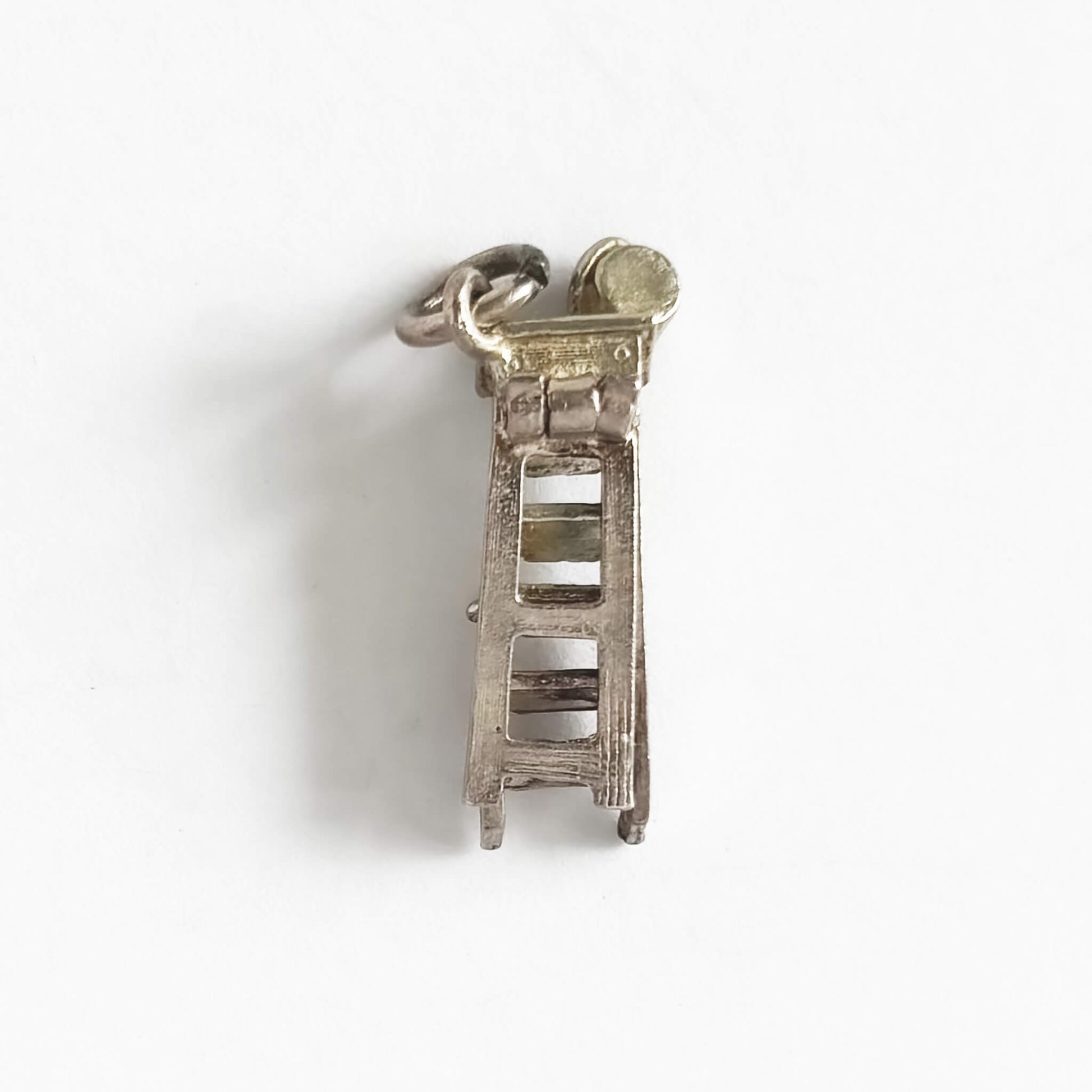 Silver ladder charm on a white background