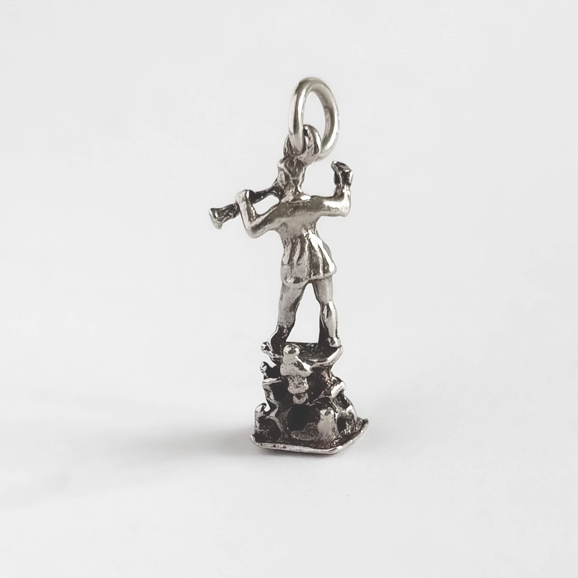Silver pendant of a pied piper on a white background