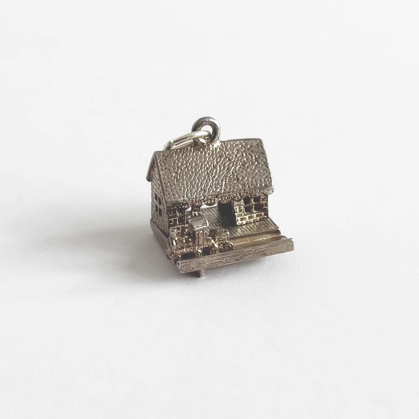 A vintage silver train in station charm on a light grey background