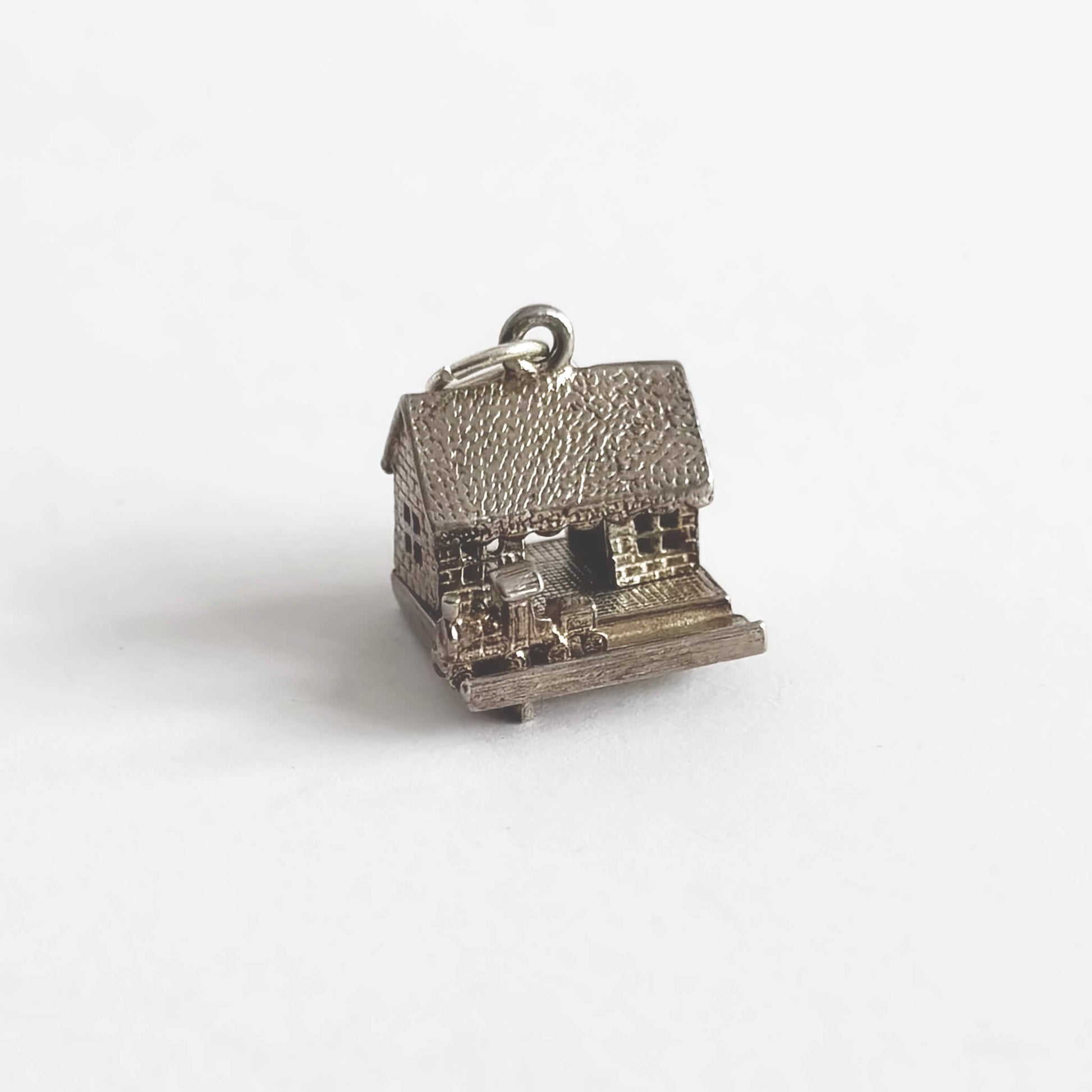 A vintage silver train in station charm on a light grey background
