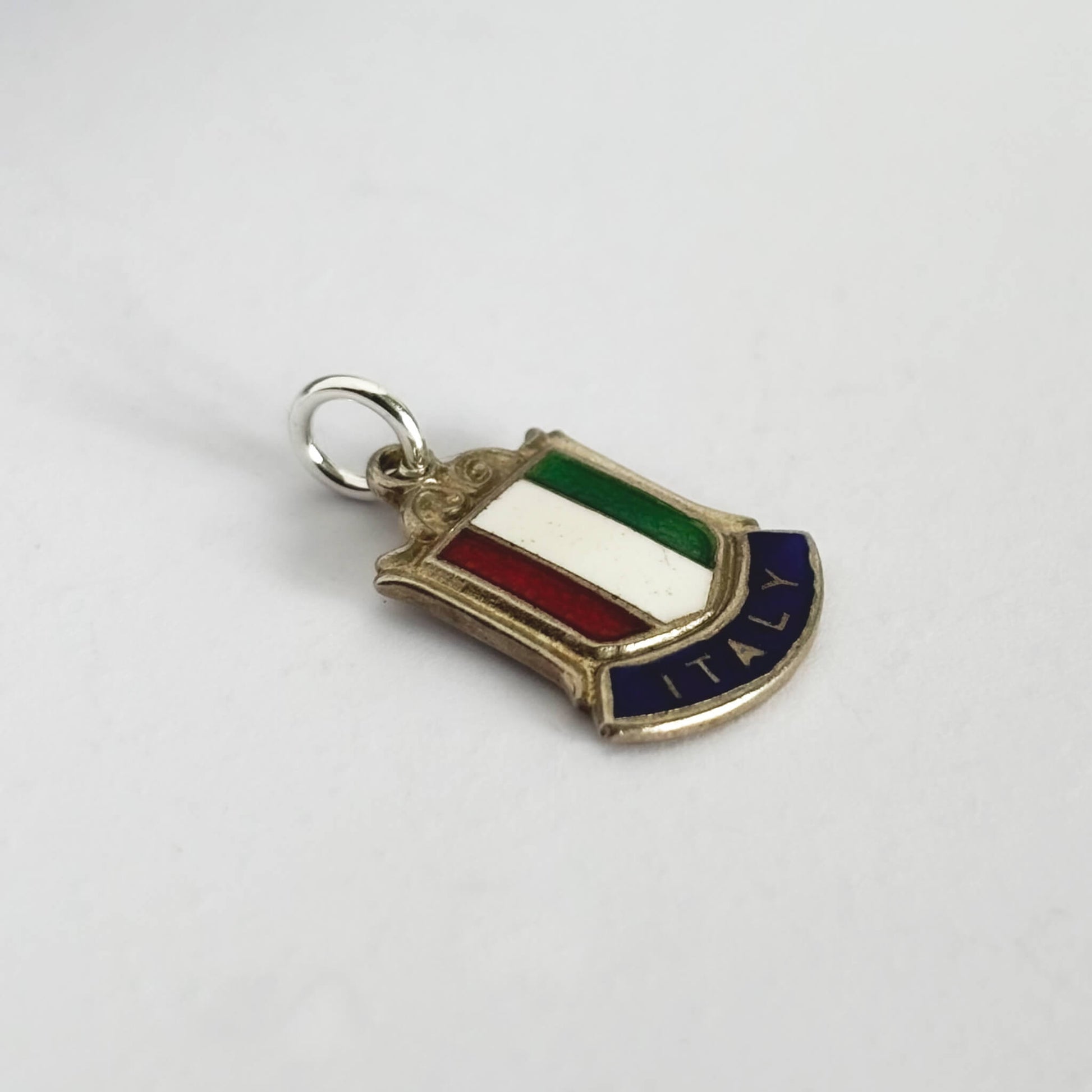 Sterling silver Italy flag travel shield charm on a white background