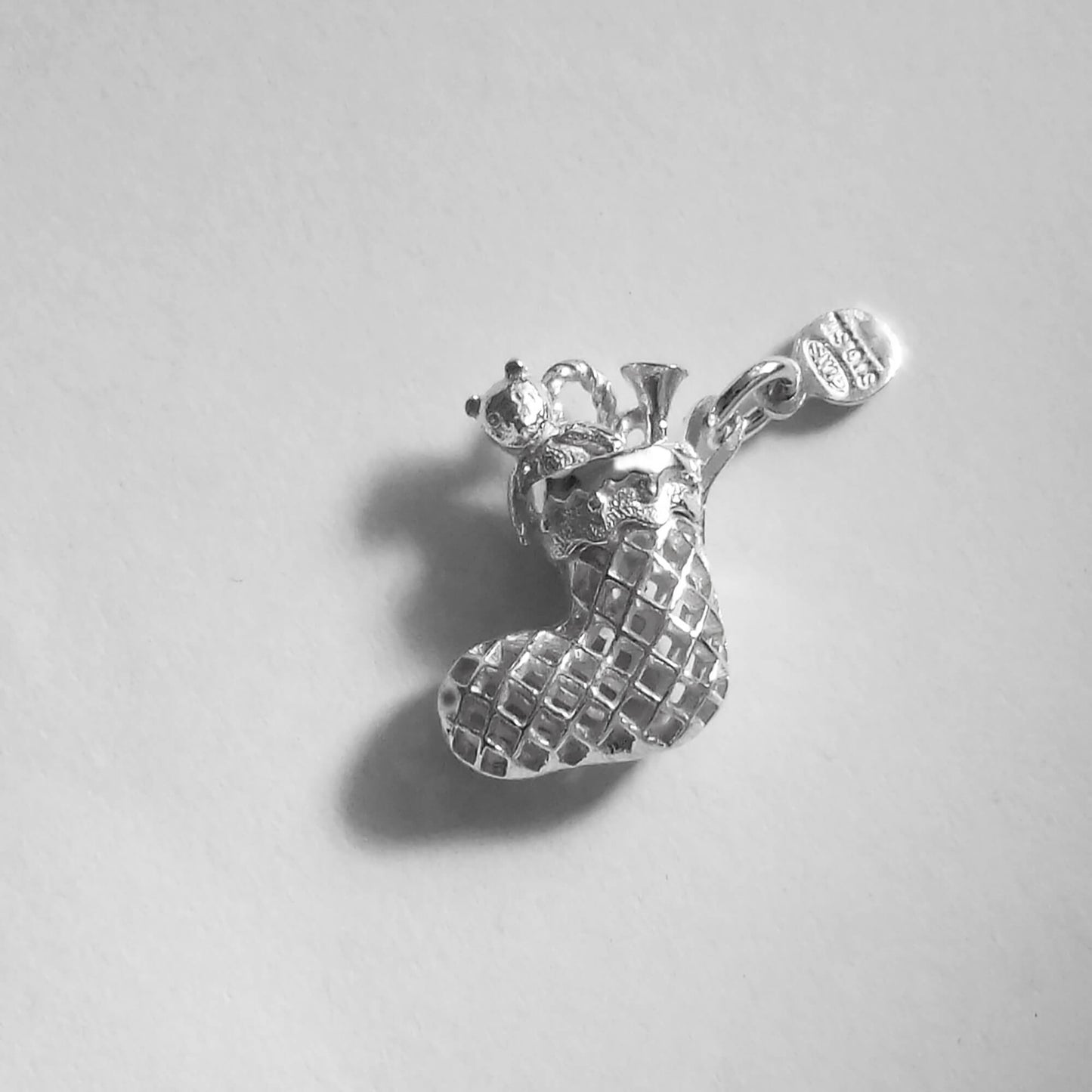silver Christmas stocking charm on grey background