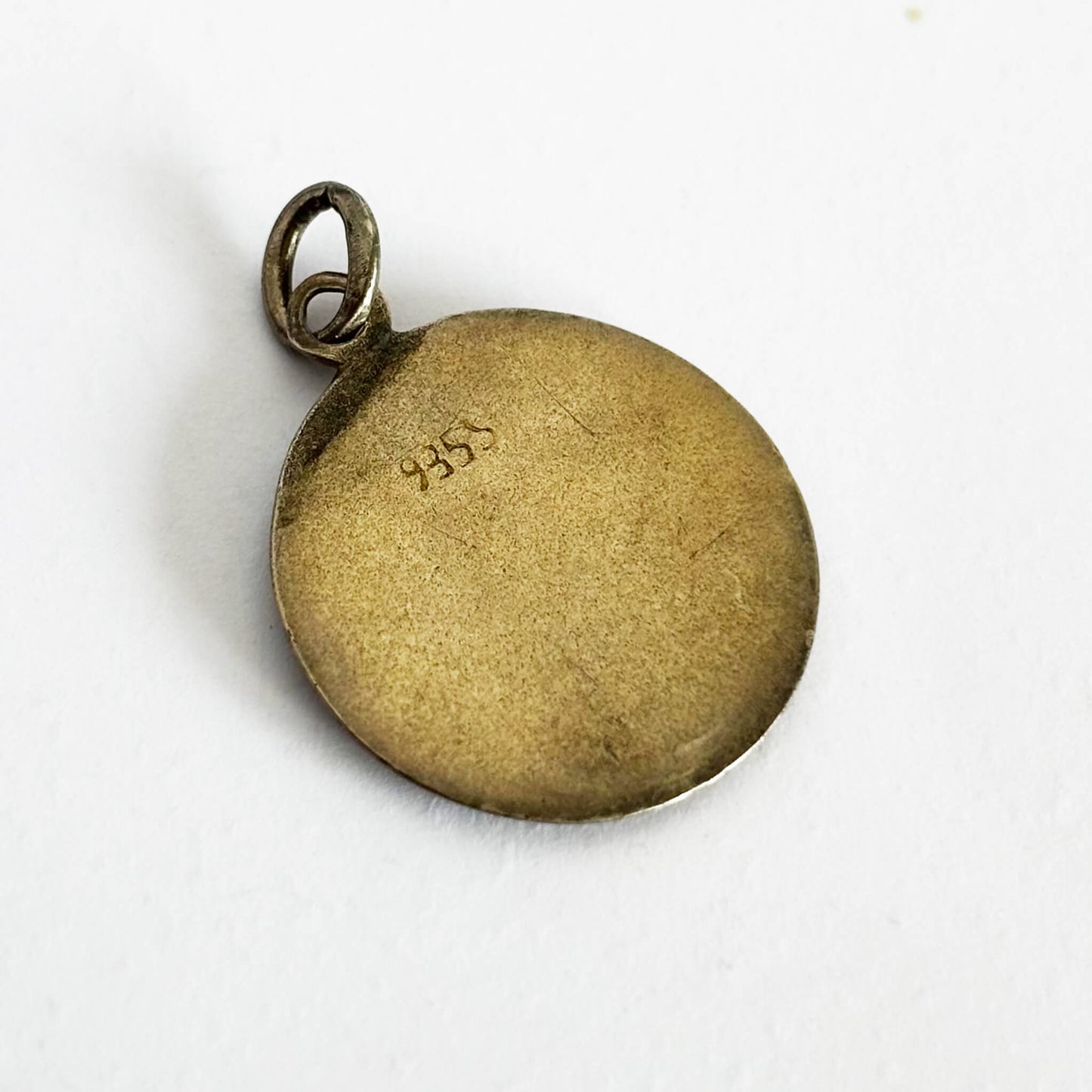 Gold pendant with '935' hallmark on a white background
