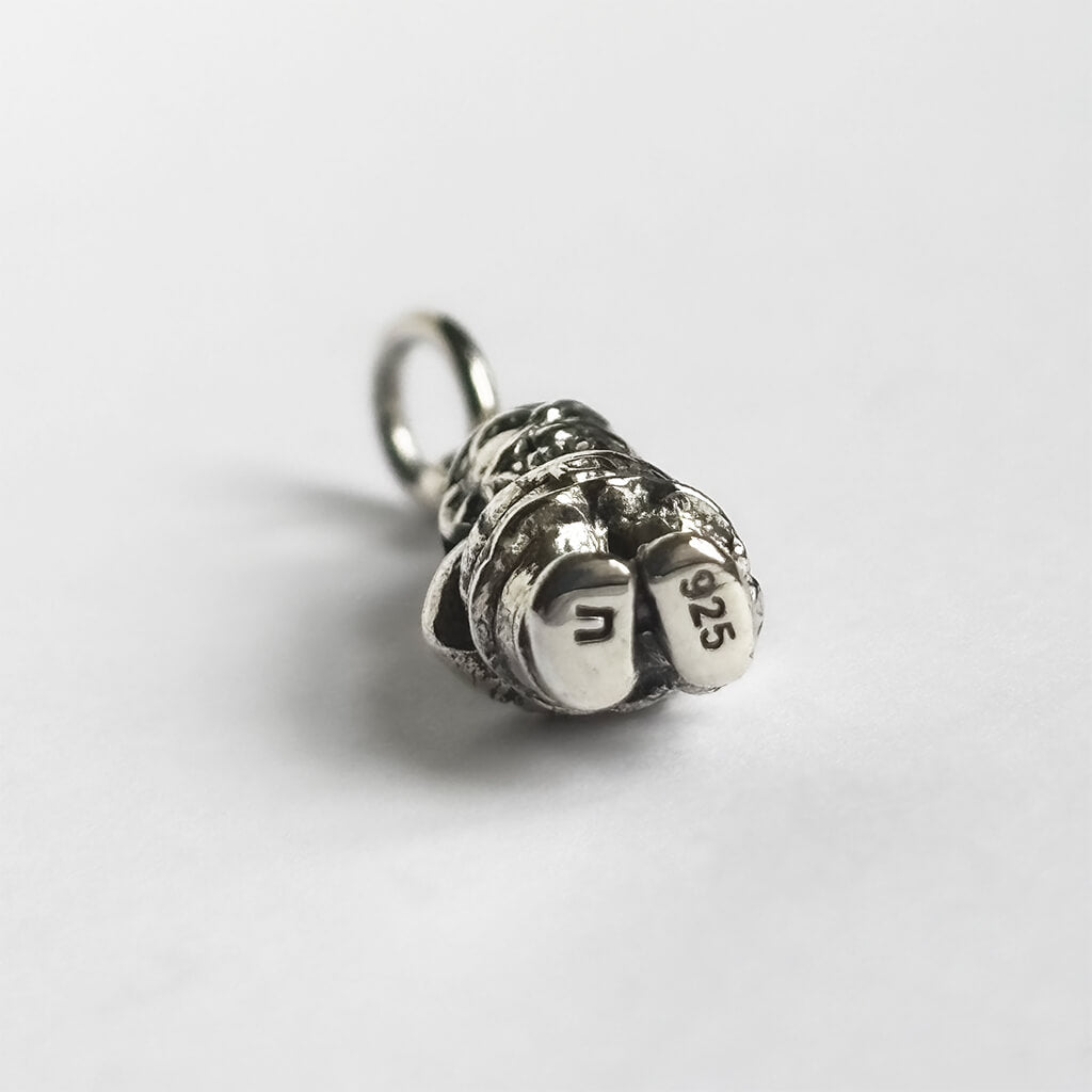Silver gnome charm from underneath on a white background
