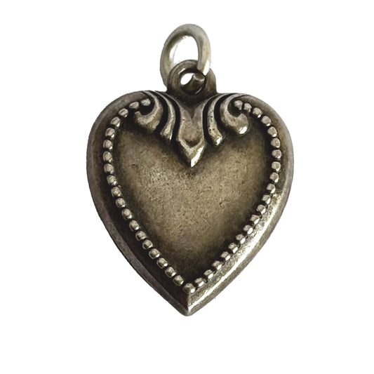 Sterling silver antique heart charm on a white background
