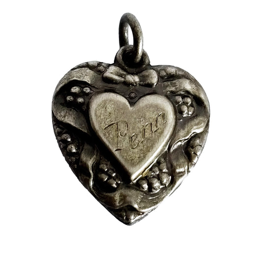Silver heart-shaped pendant with engraved name on a white background