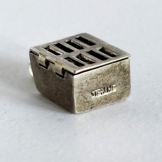 Sterling silver prison cell charm on a light grey background