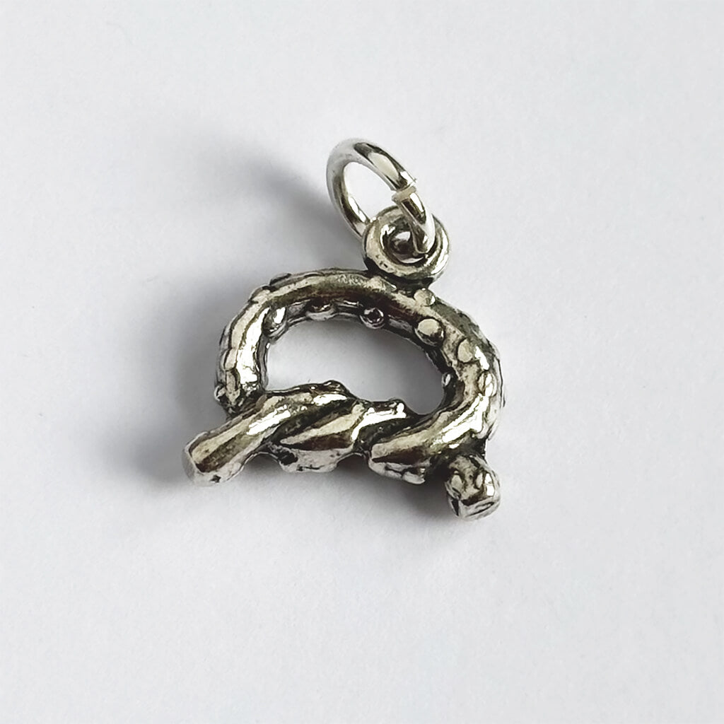 Silver pretzel pendant on a light gray background