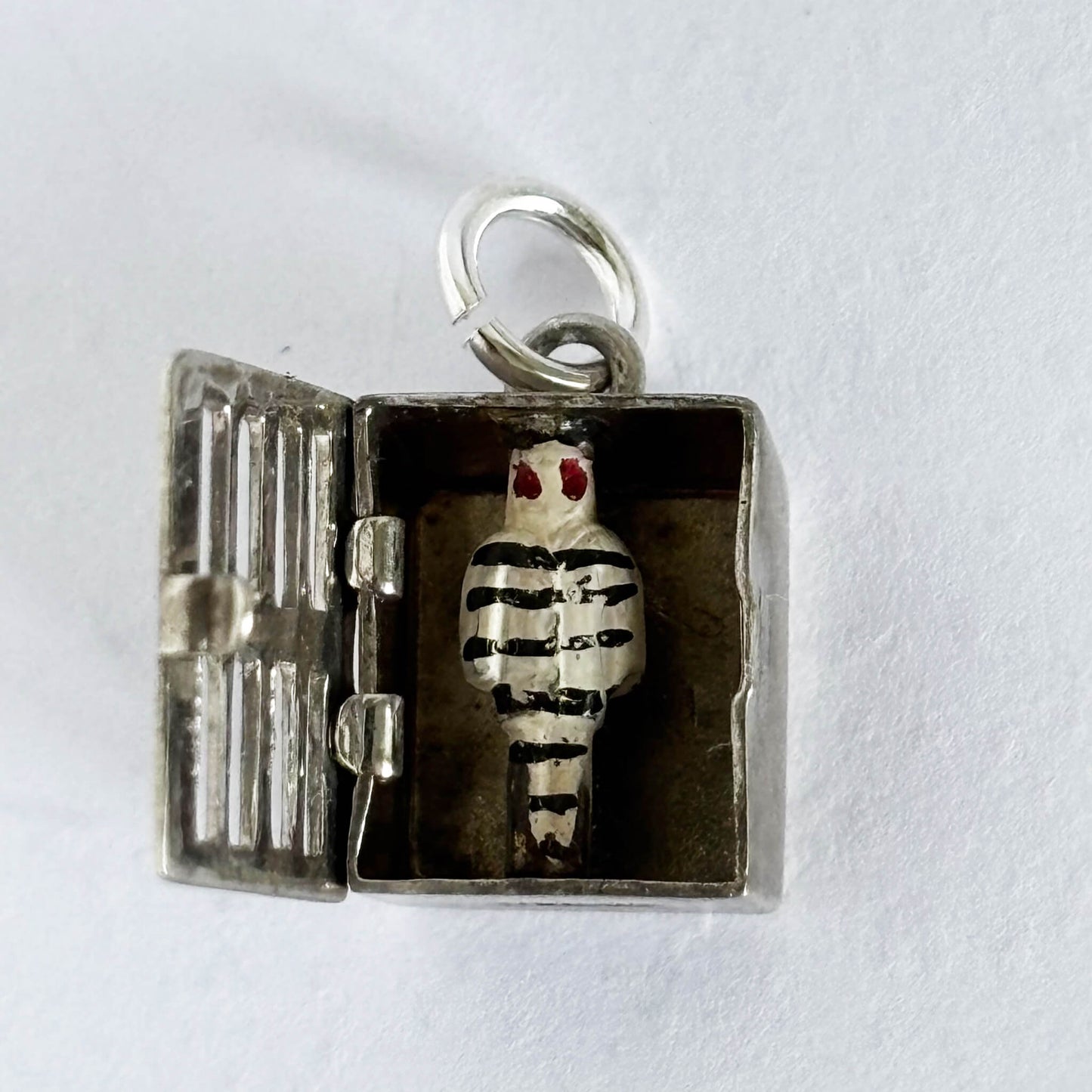 Sterling silver jailbird in jail cell charm on a white background
