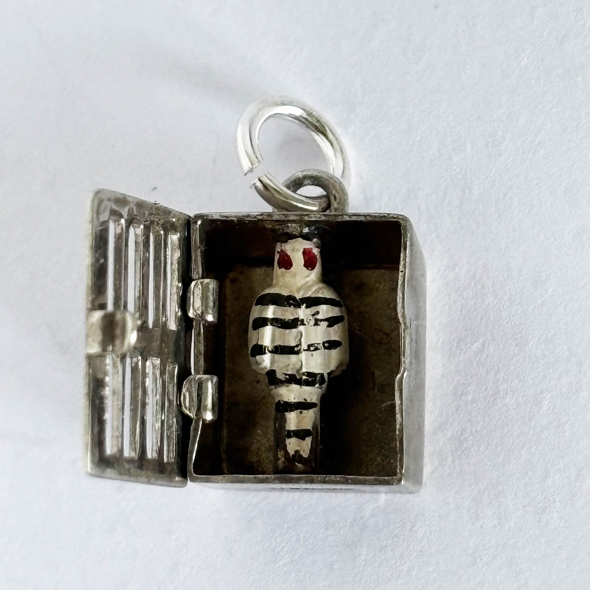 Sterling silver jailbird in jail cell charm on a white background