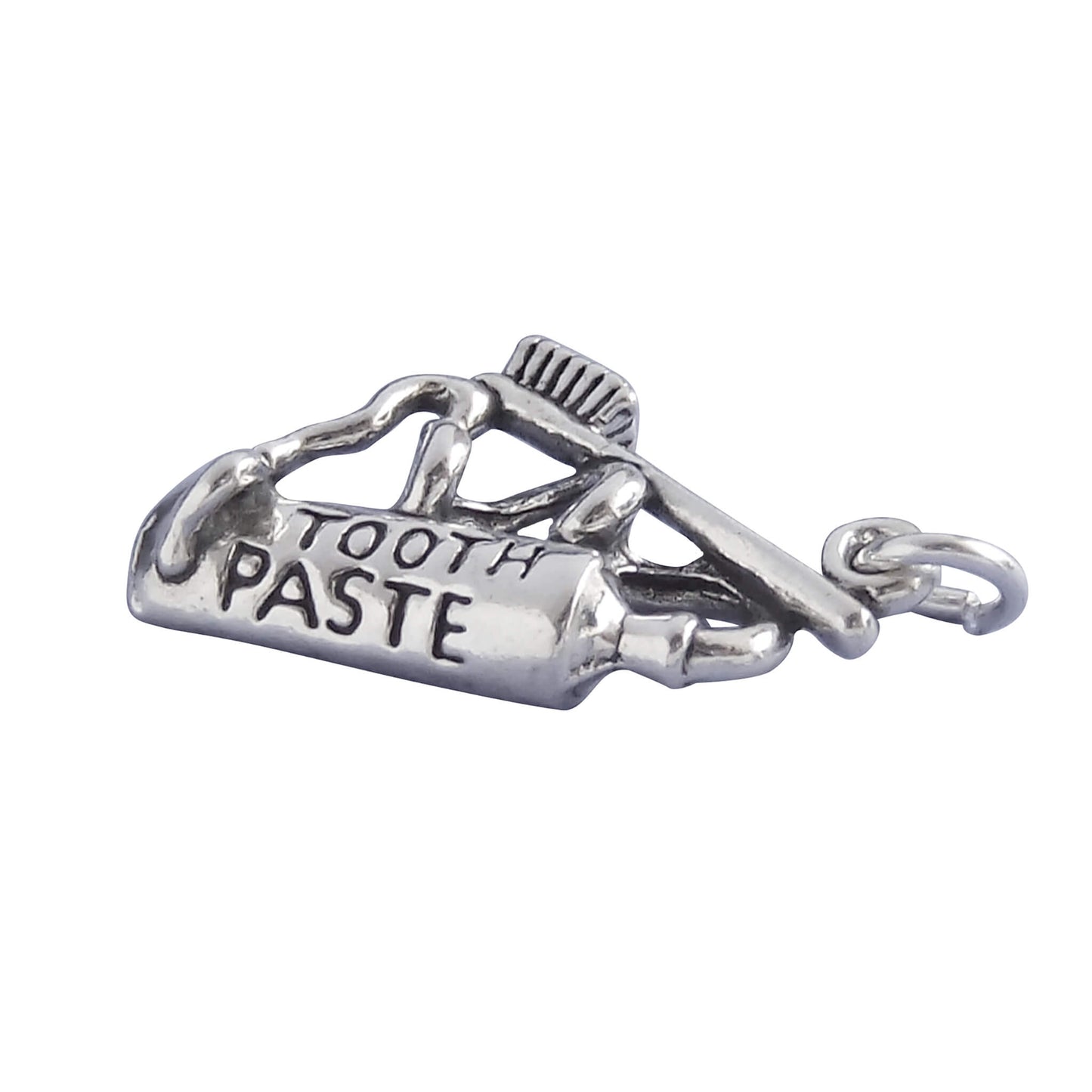 Silver toothpaste and toothbrush charm on white background