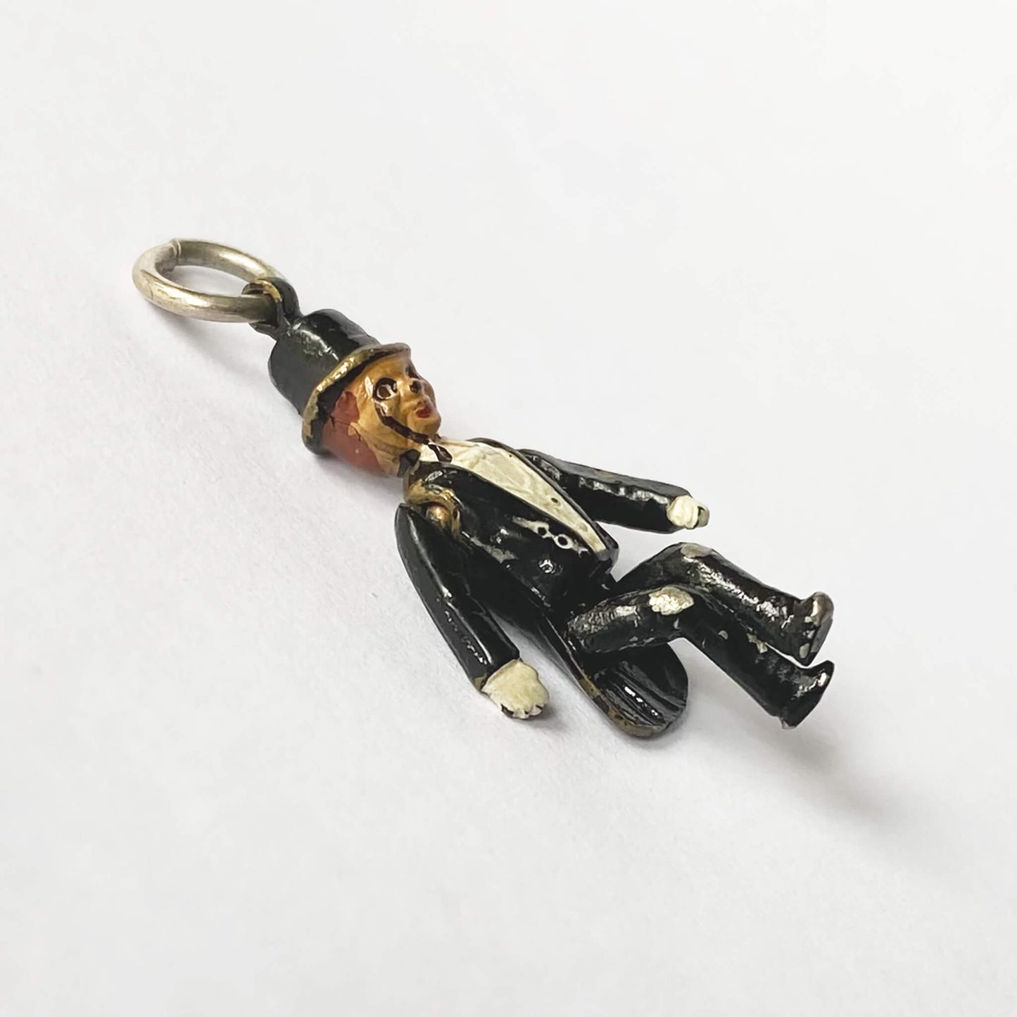 Vintage Charlie McCarthy ventriloquist dummy charm with enamel on a white background