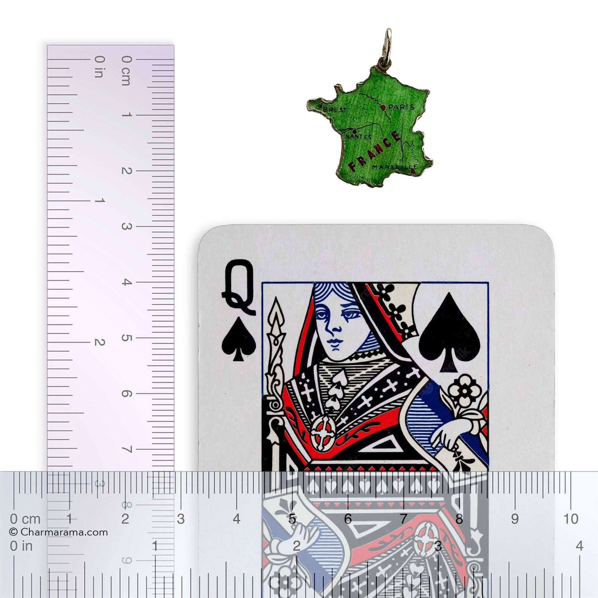 Green enamel France map charm with playing card and ruler on white background