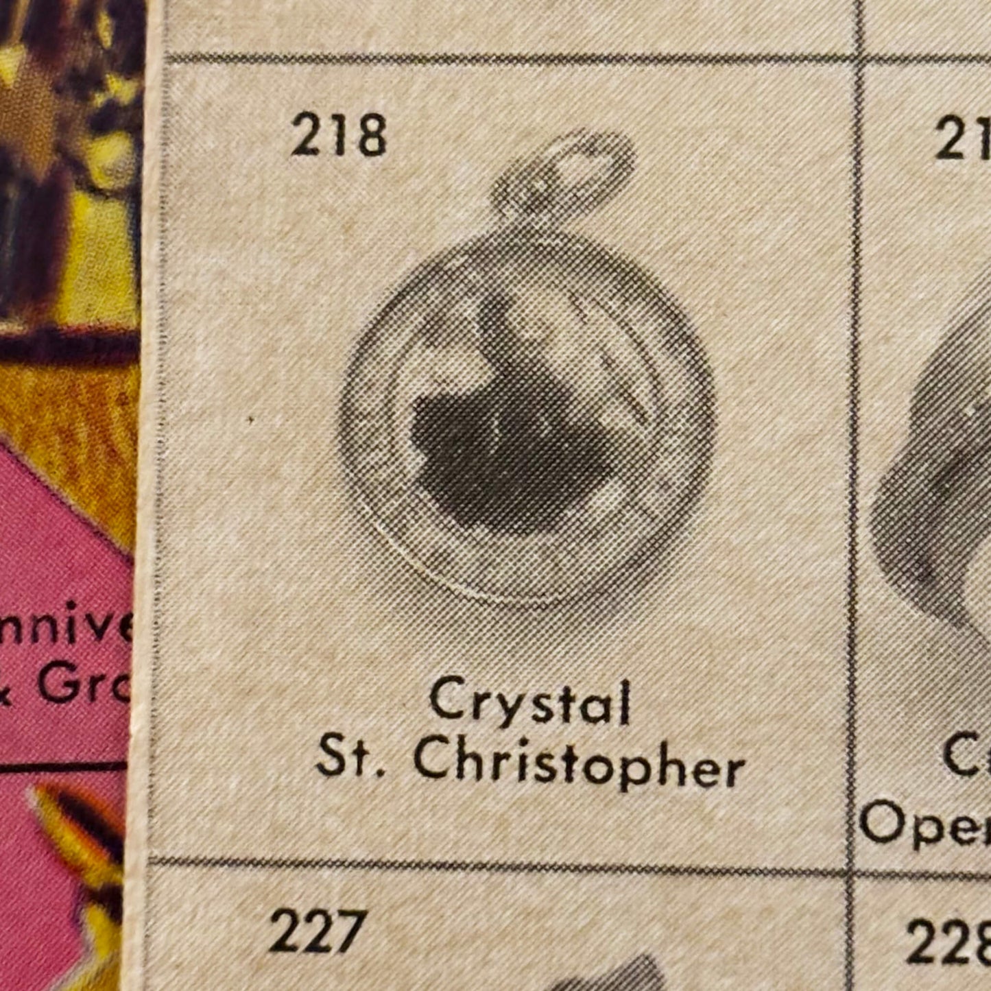 Close-up of a catalog page with a crystal St. Christopher pendant.