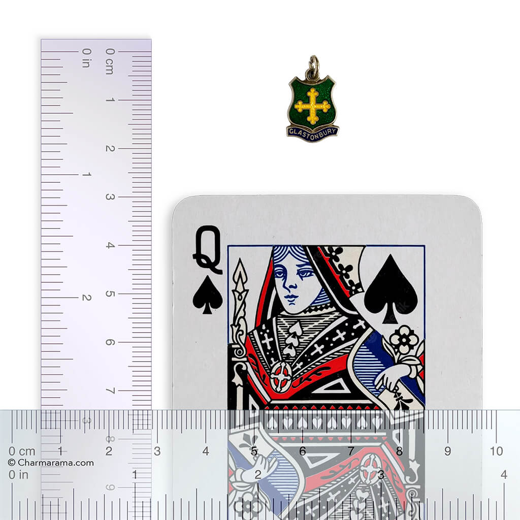Playing card with Queen of Spades design next to a ruler for scale, with a Glastonbury pendant above the card.