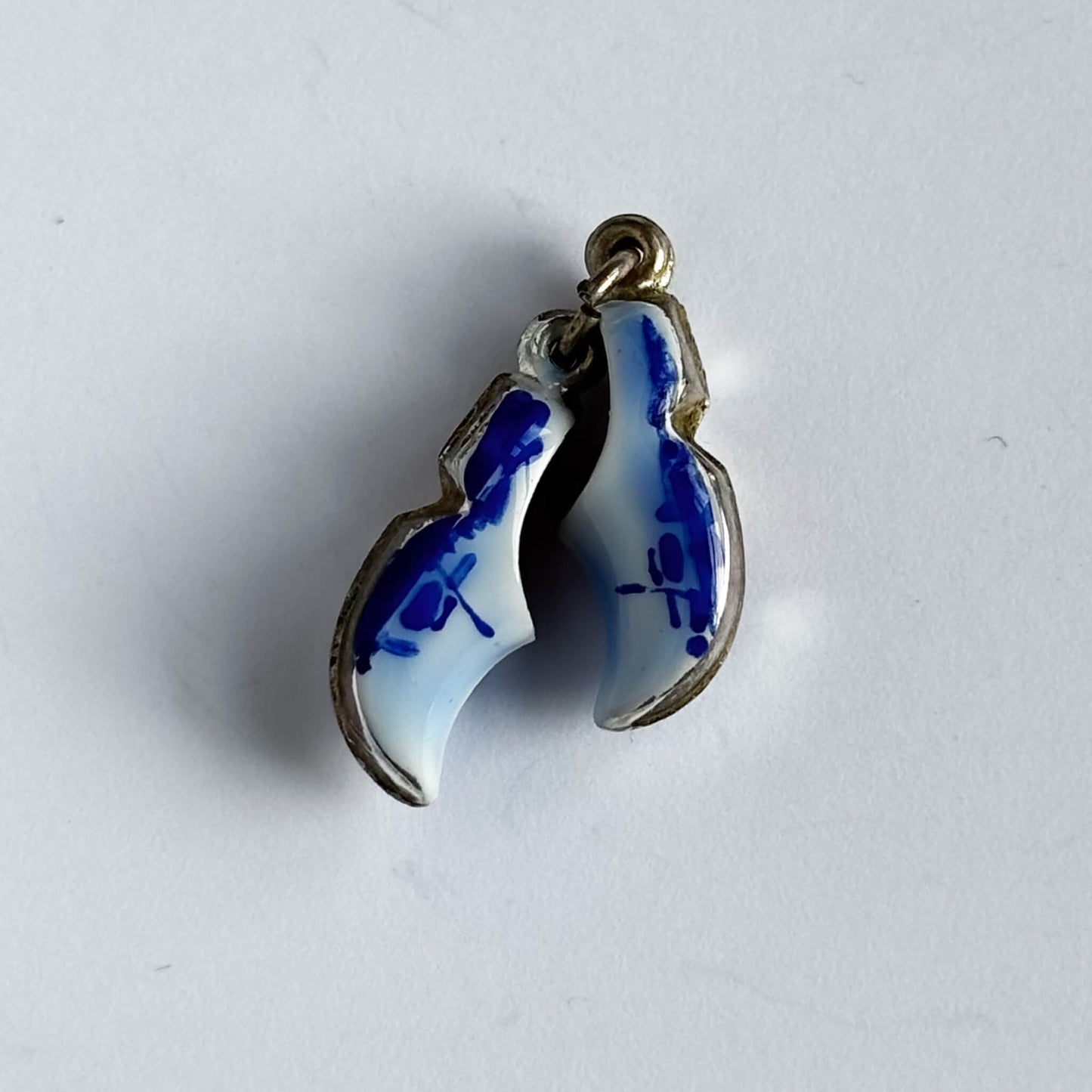 Silver Dutch clogs charm with blue enamel on white background