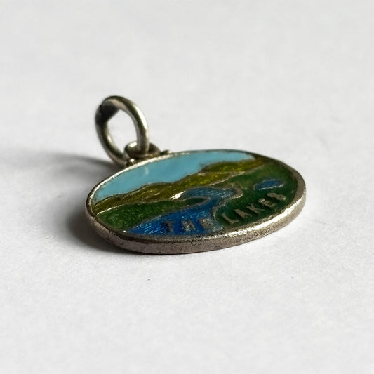 Vintage sterling silver and enamel The Lakes charm on white background