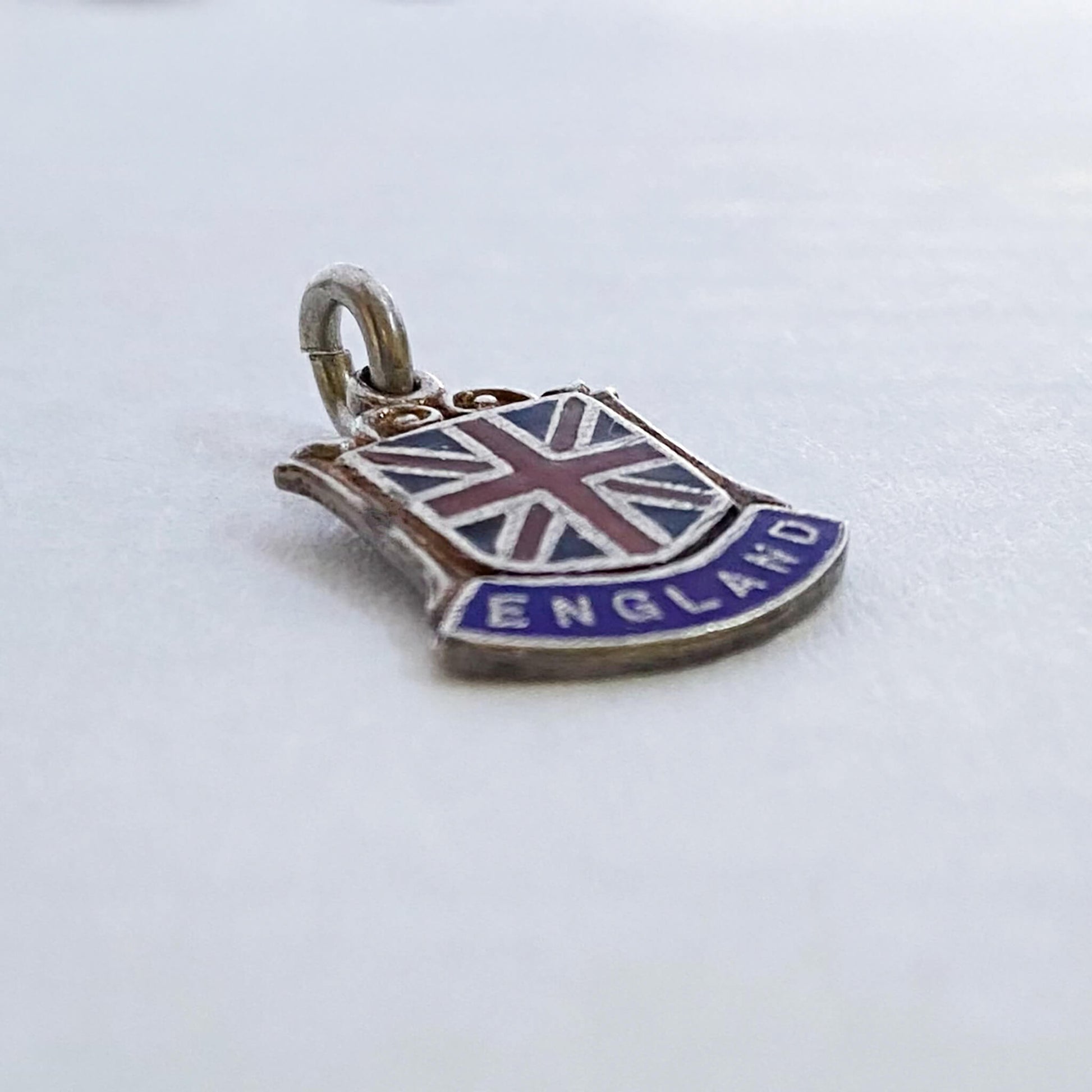 Vintage silver pendant with Union Jack design and 'England' text on a white background