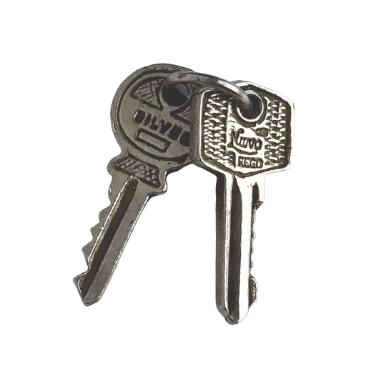 Nuvo vintage charm of two sterling silver keys on a white background