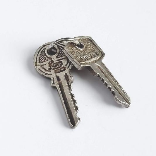 Nuvo vintage charm of two sterling silver keys on a white background