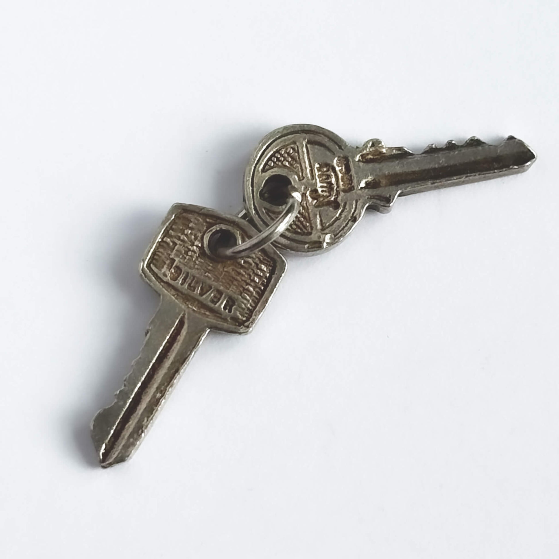 Nuvo 1960s vintage charm of two sterling silver keys on a white background