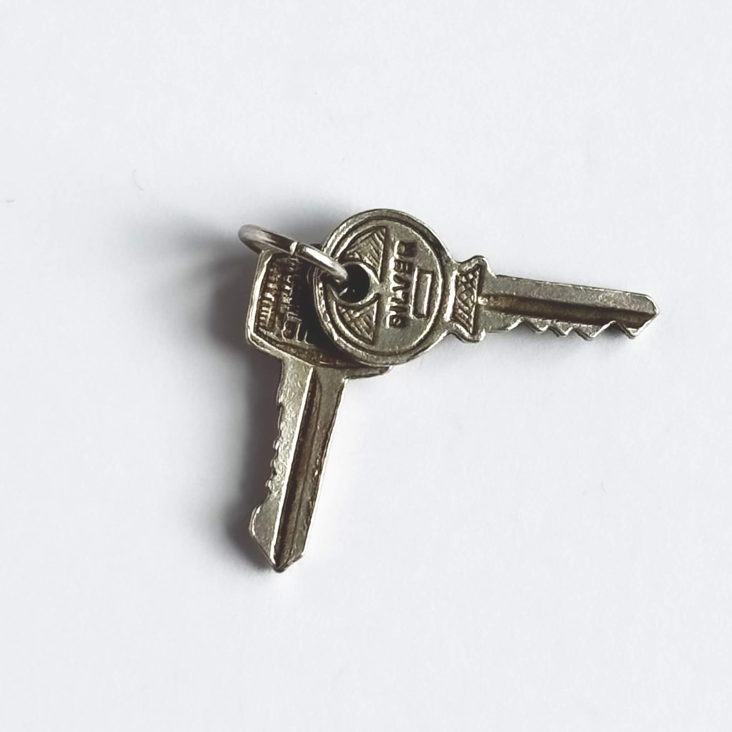 Nuvo vintage charm of two sterling silver keys on a white background