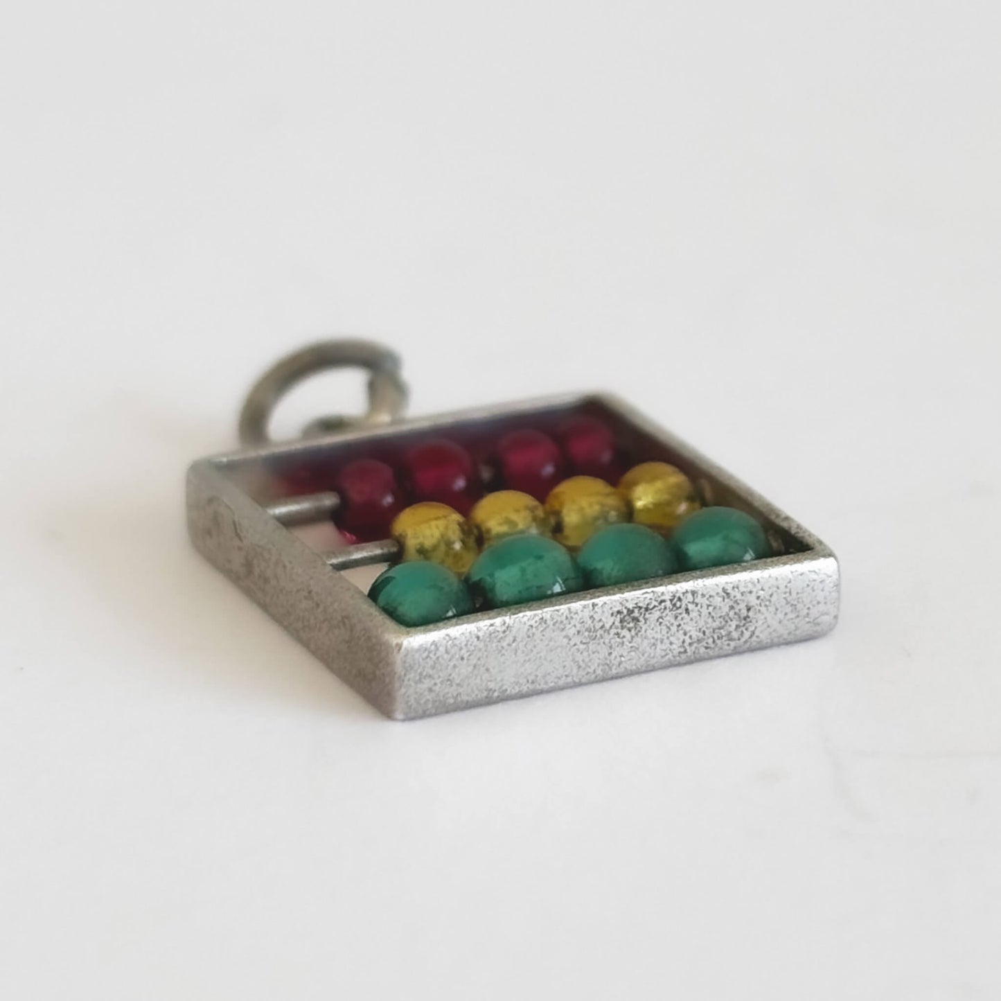 Abacus charm with coloured beads on a white background