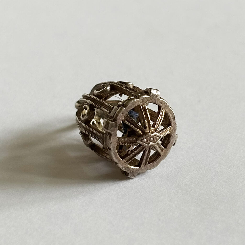 Bird cage charm on a light gray background