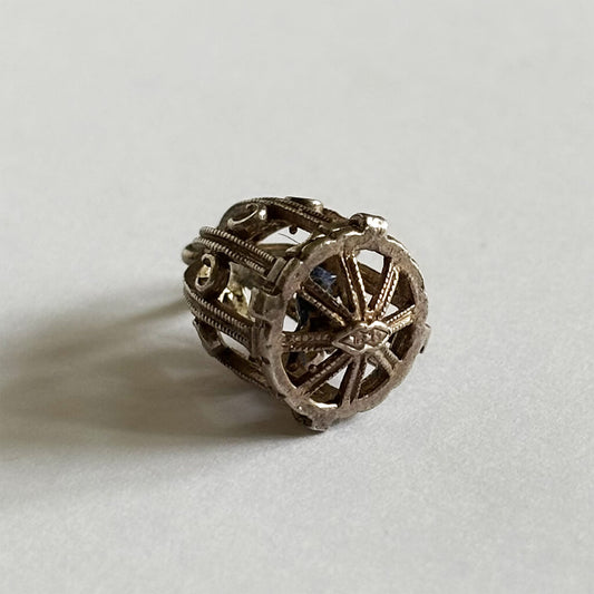 Bird cage charm on a light gray background