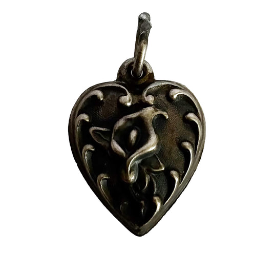 Heart-shaped pendant with intricate calla lily flower design on a white background