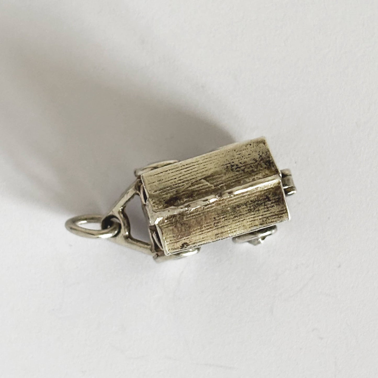 silver circus wagon charm seen from above on a white background