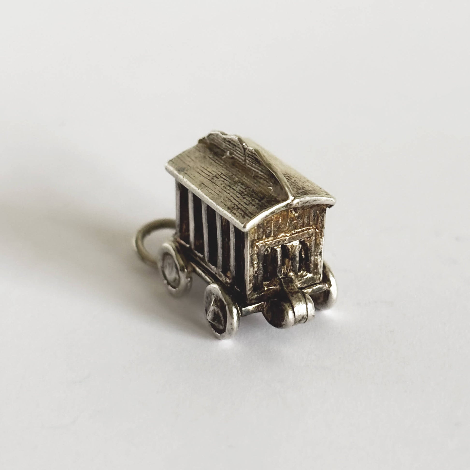 silver circus wagon charm on a white background