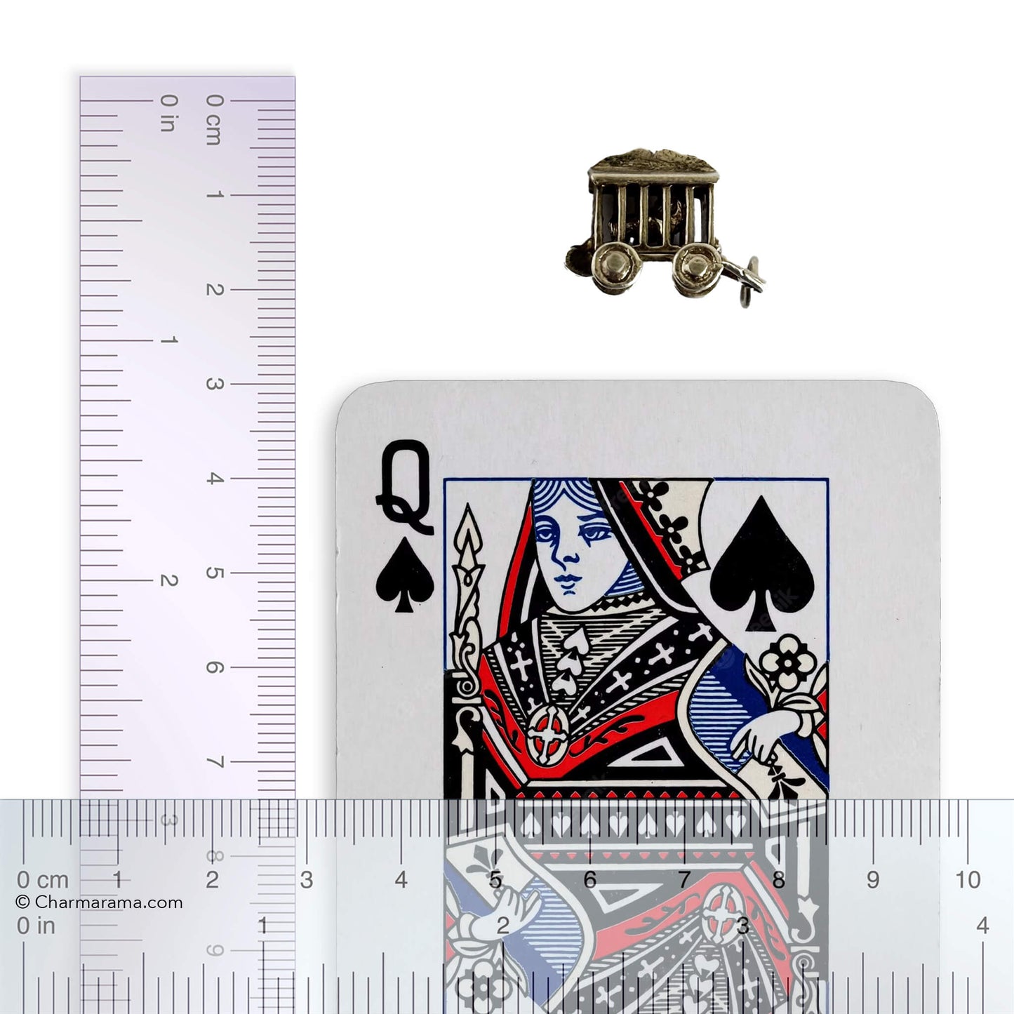 silver circus wagon charm with lion inside with playing card and ruler for scale on a white background