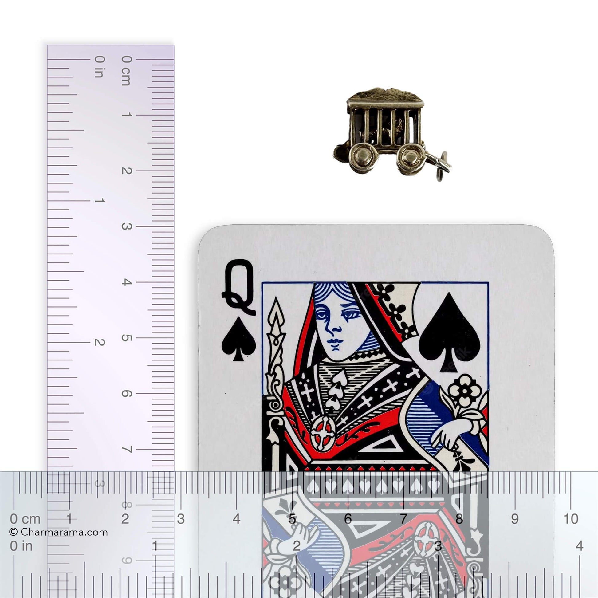 silver circus wagon charm with lion inside with playing card and ruler for scale on a white background