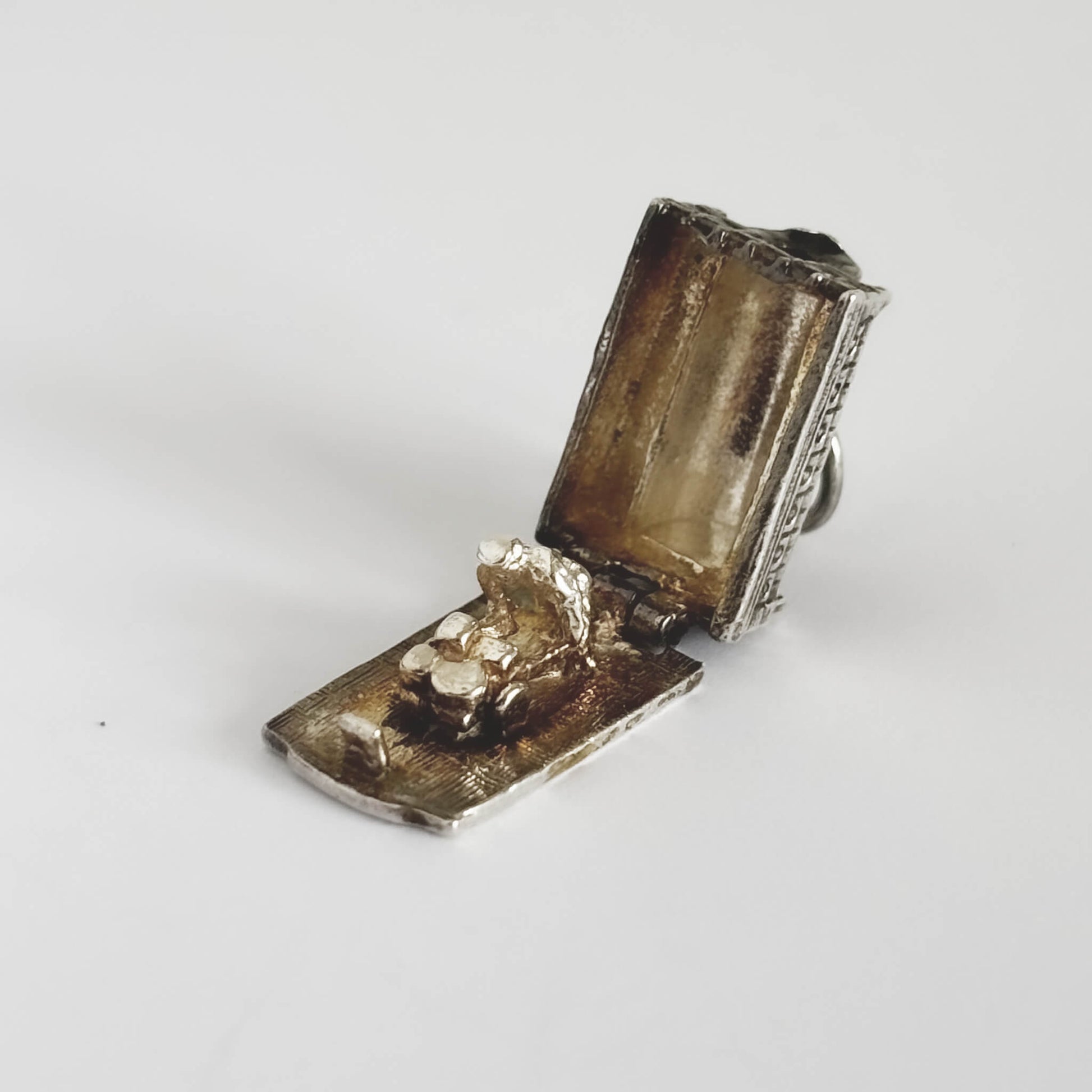 A silver Covent Garden charm open showing a market holder and barrow on a white background