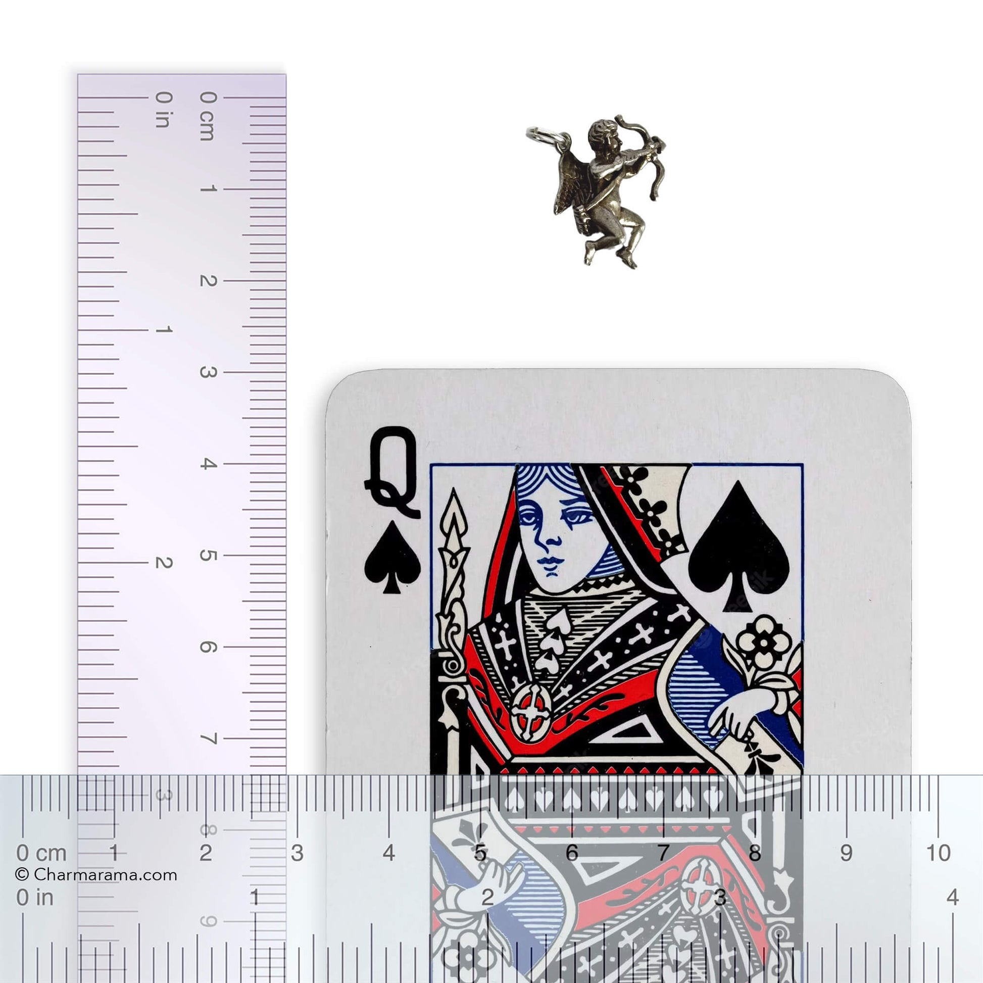 Small silver angel figurine next to a playing card with a ruler for scale.